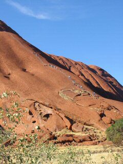 Den Uluru besteigende Touristen